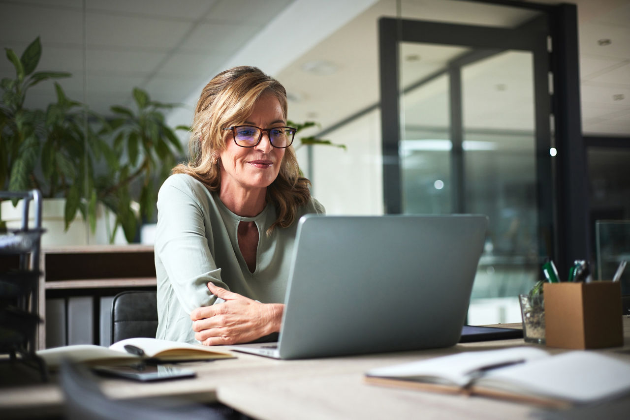 Laptop, working and senior business woman in office reading online project, report and research. Creative workspace, planning and female manager on computer for website, information and writing email