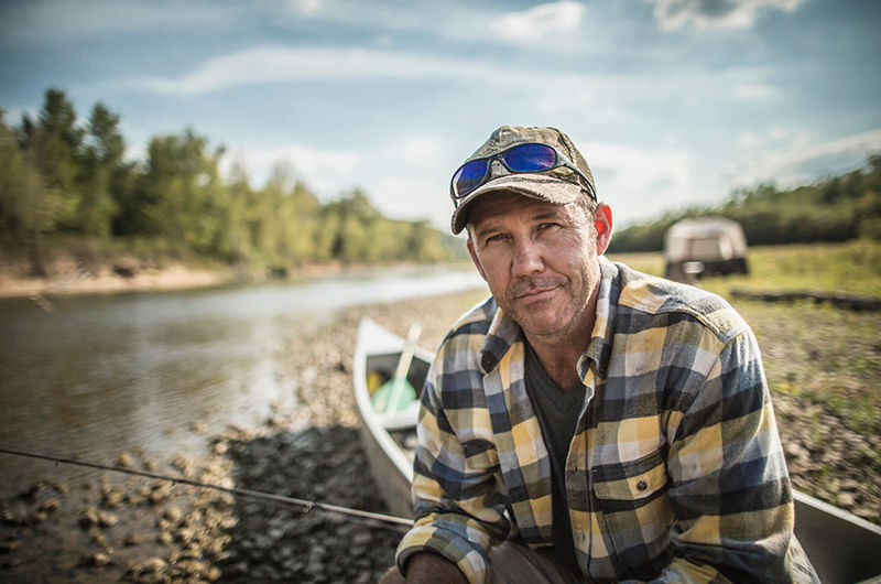 Caucasian man sitting in canoe on riverbed