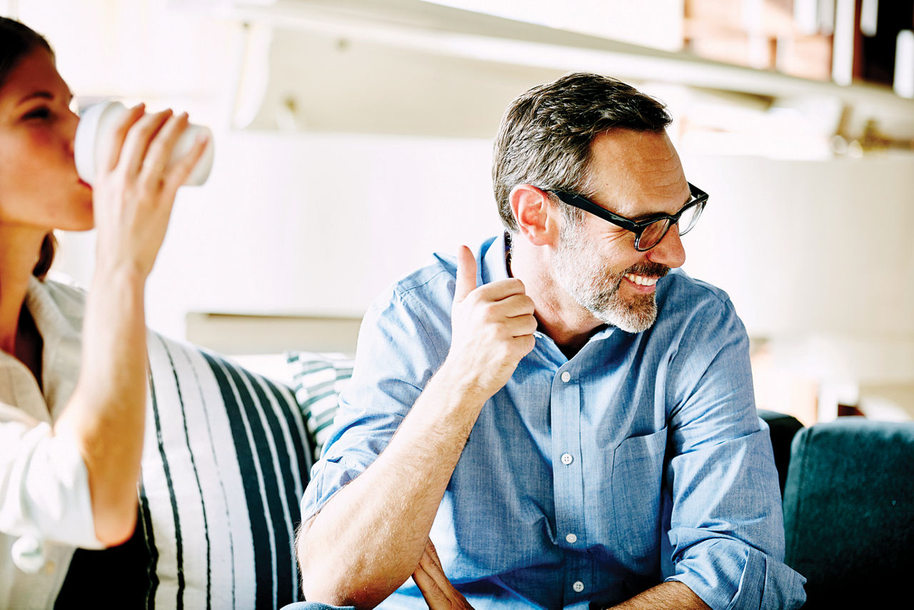 Laughing businessman in informal meeting in office with colleagues