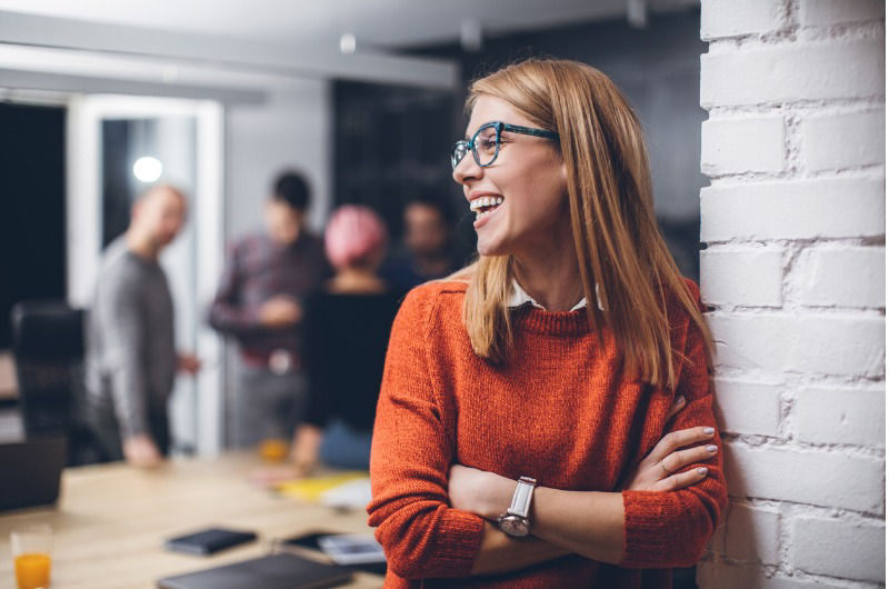 The girl standing wearing eyeglass