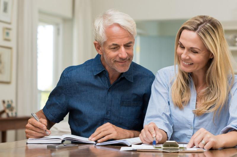 man and woman looking at notepads