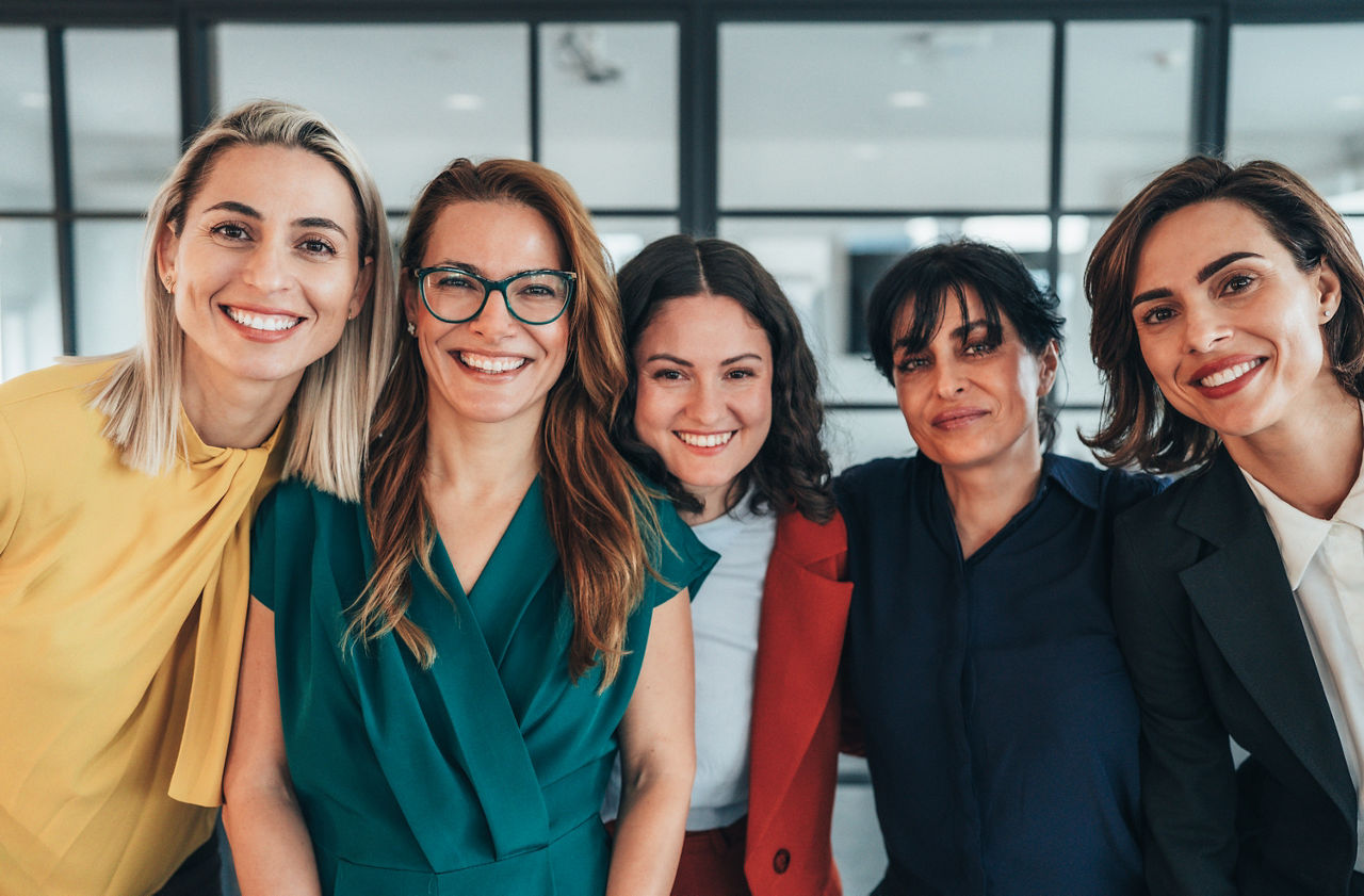 A confident team of women business professionals stands together, symbolizing collaboration, leadership, and shared ambition. Their professional attire and poised expressions reflect experience and determination, while their united stance conveys strength, trust, and mutual support